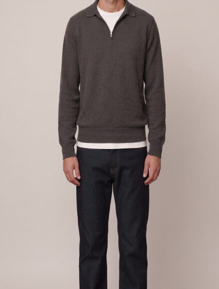 A tall man wearing a charcoal quarter-zip sweater over a white tee, showing correct body length