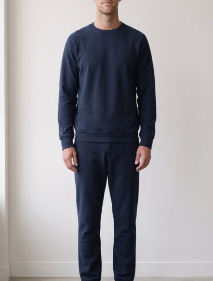 Tall man in a matching deep navy sweatshirt and navy joggers forming one unbroken vertical line of colour