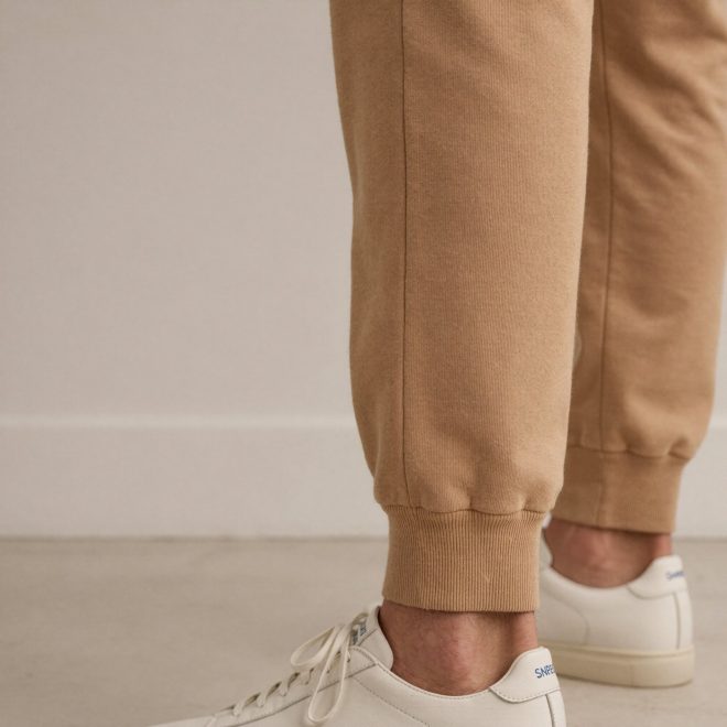 Camel jogger sweatpants with the elastic cuff sitting high above the ankle bone on a tall man