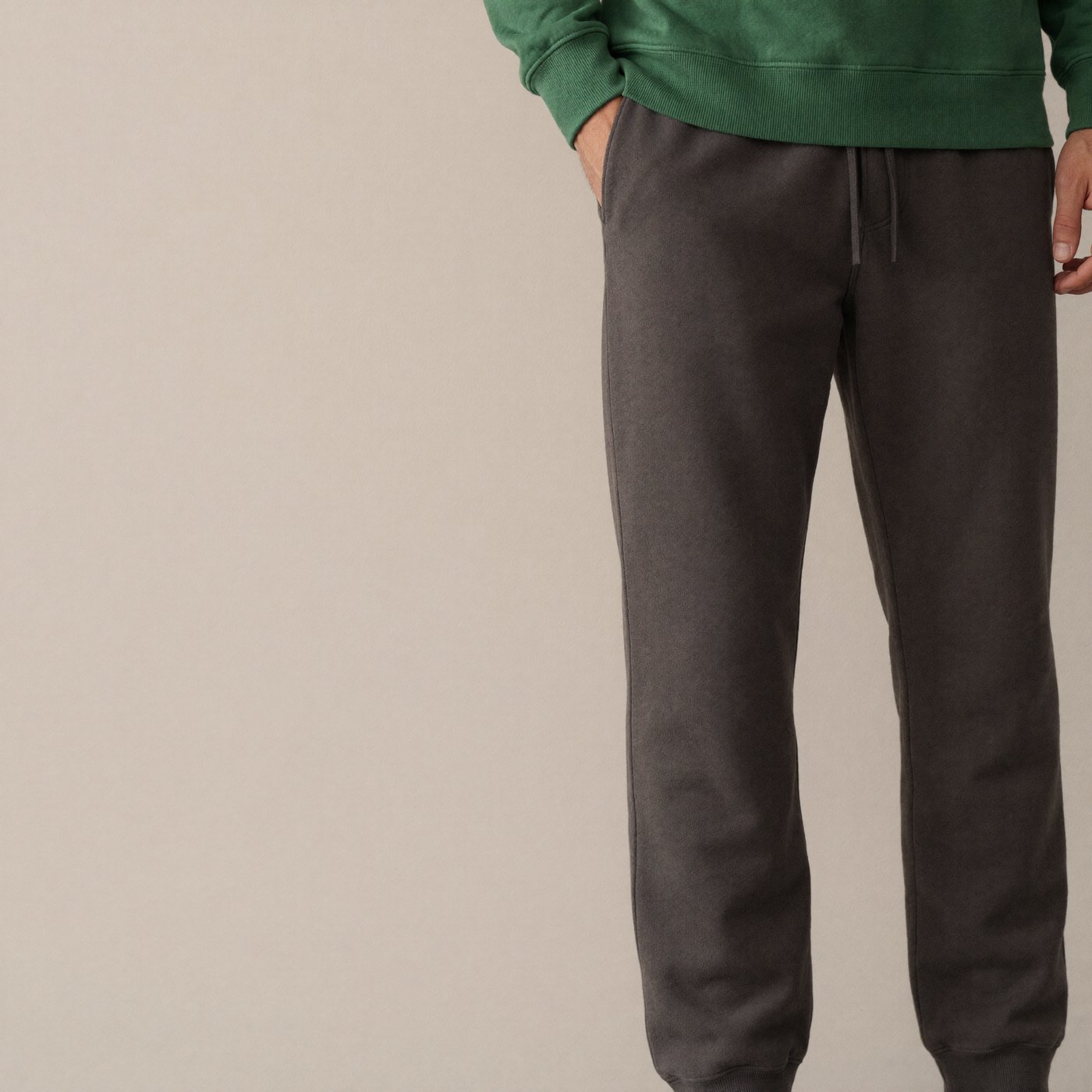 Charcoal technical fleece joggers holding a sharp taper down a long leg